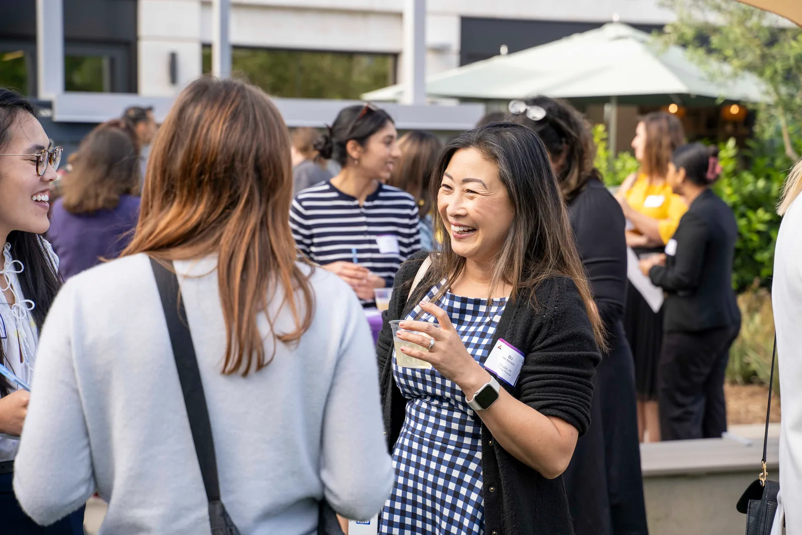 Two attendees laughing together during the 2025 Athena STEM Summer Wine Social